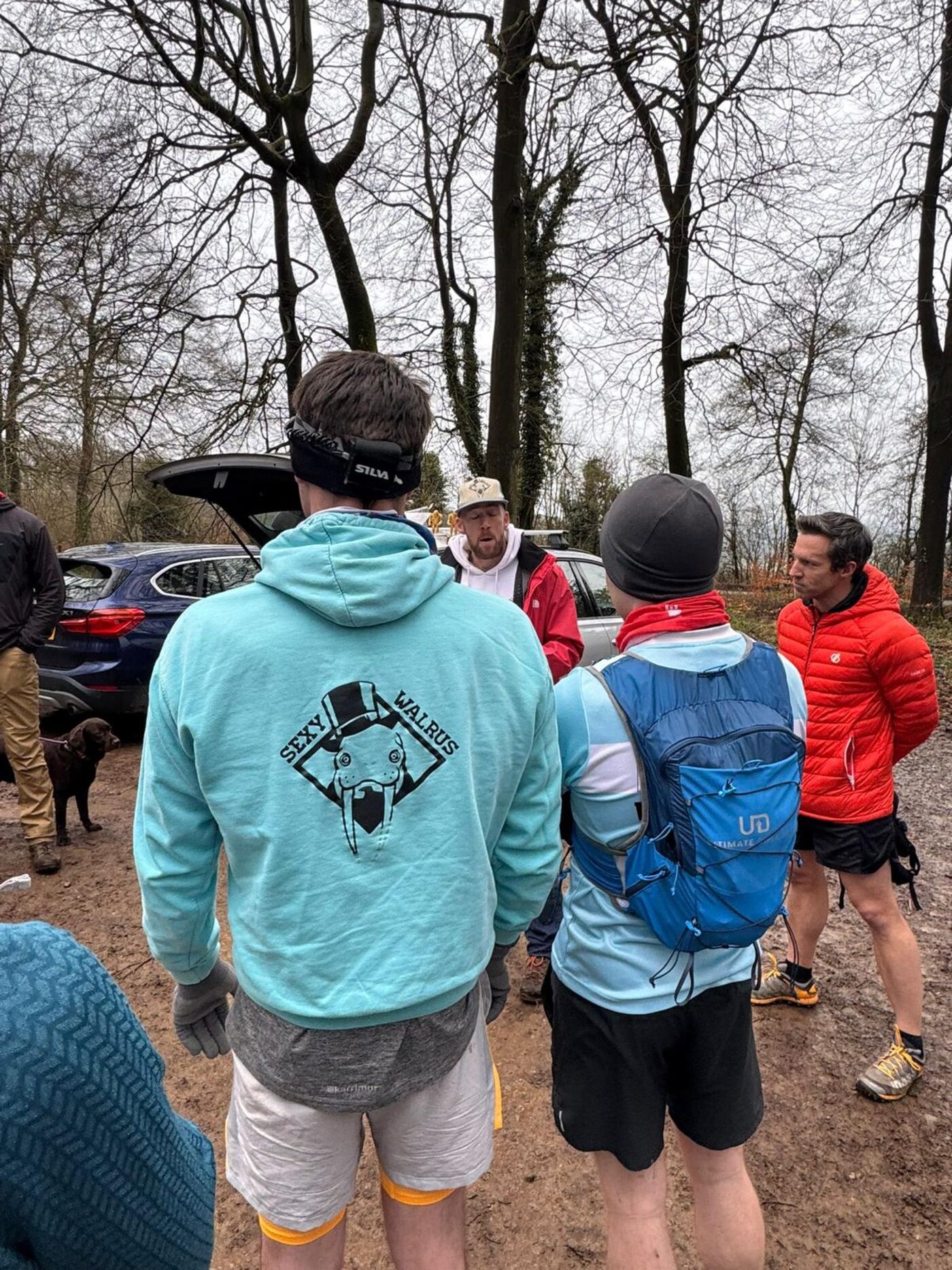 Three members seen from behind in a car park, one in the club's hooded top