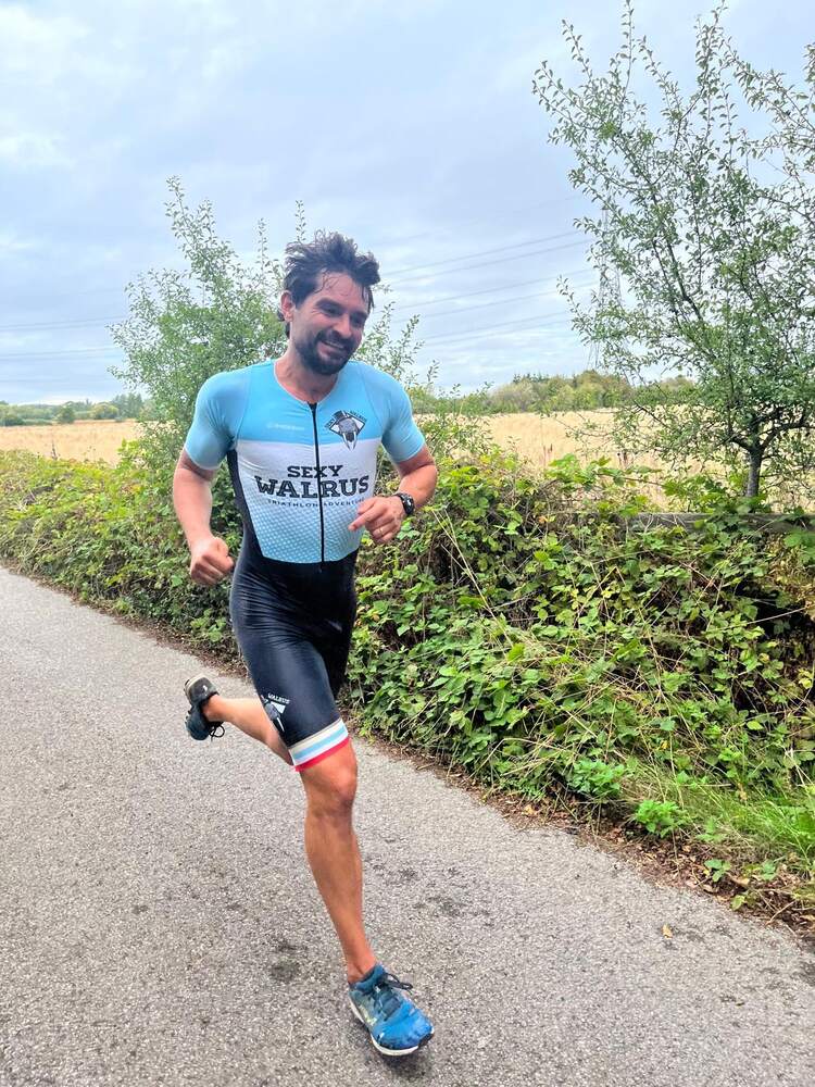 A member running on a path, smiling, in club kit