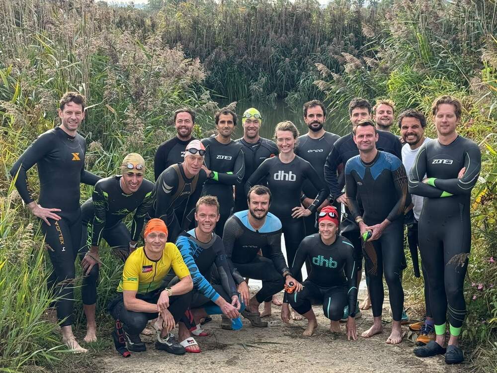 Members in wetsuits at the water before the swim start